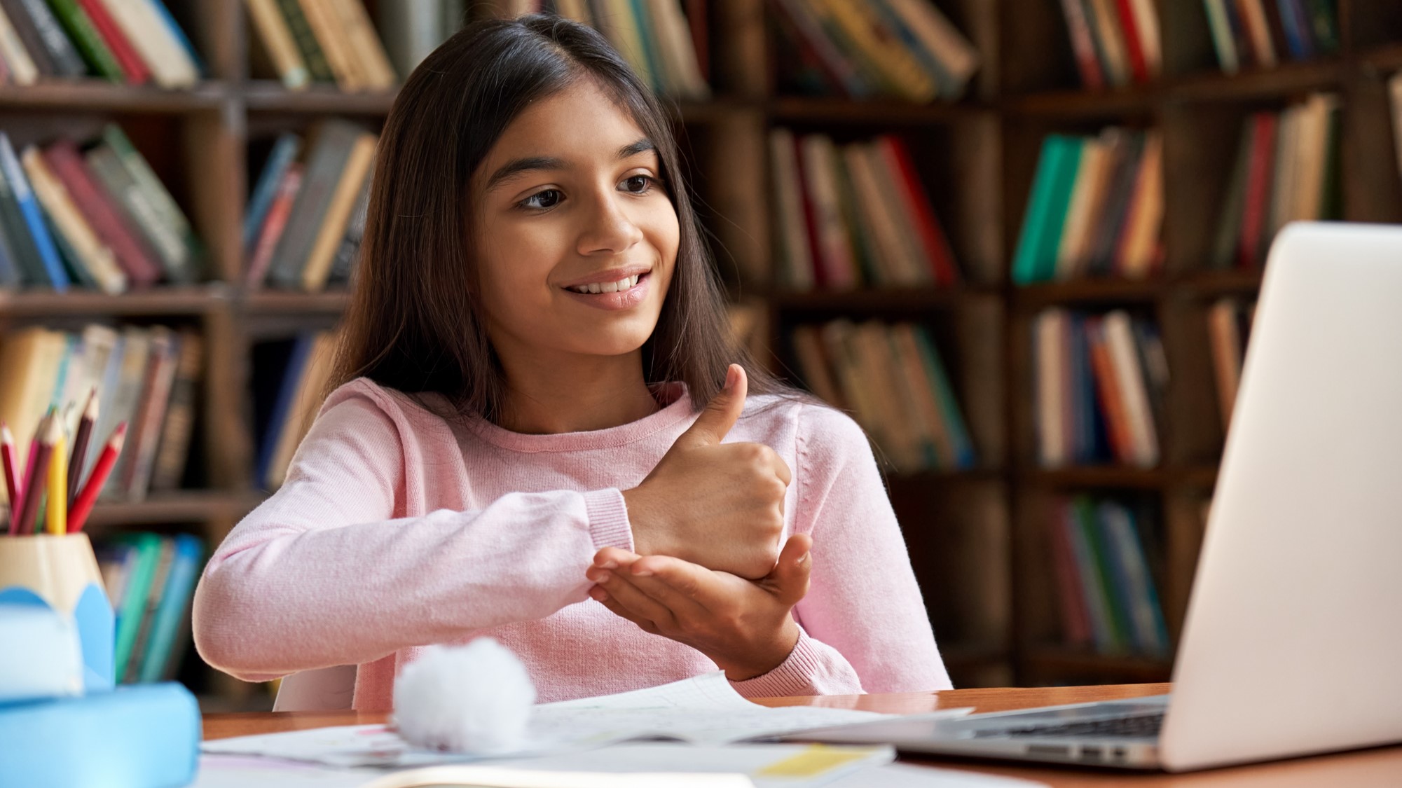 Child in a library, signing "Help"